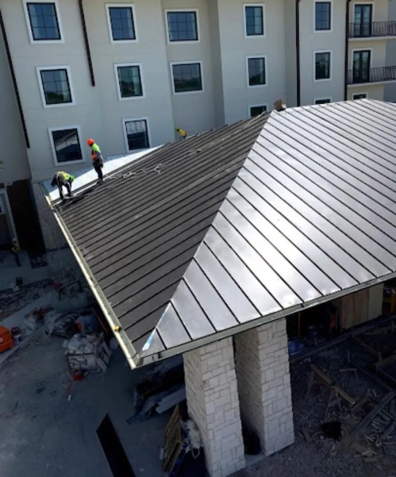 Crew installing standing seam metal roof panels on a commercial project in Maryville